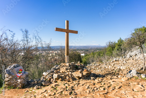 A landscape photo of the wooden cross at the apparition hill in Medjugorje, Bosnia and Herzegovina.