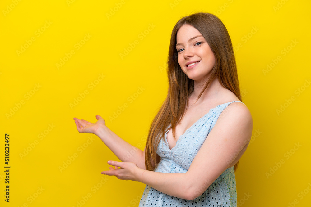 Young caucasian woman isolated on yellow background extending hands to the side for inviting to come Young caucasian woman isolated on yellow background extending hands to the side for inviting to come