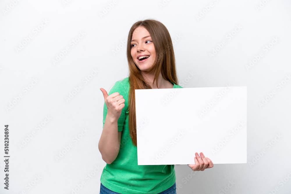 Young caucasian woman isolated on white background holding an empty placard and pointing side Young caucasian woman isolated on white background holding an empty placard and pointing side