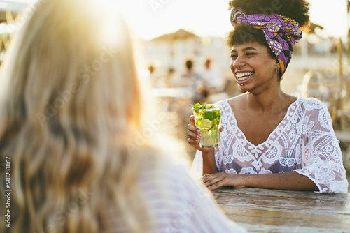 Canvas Print Happy girls having fun drinking alcohol free mojito at cocktail bar on the beach