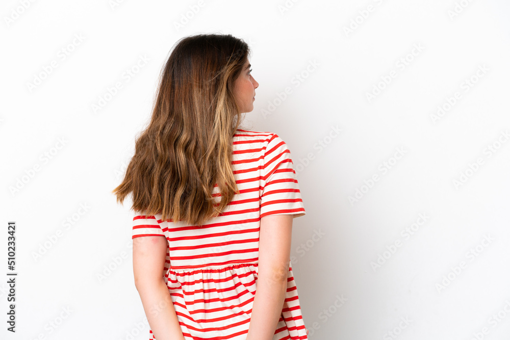 Young caucasian woman isolated on white background in back position and looking back Young caucasian woman isolated on white background in back position and looking back