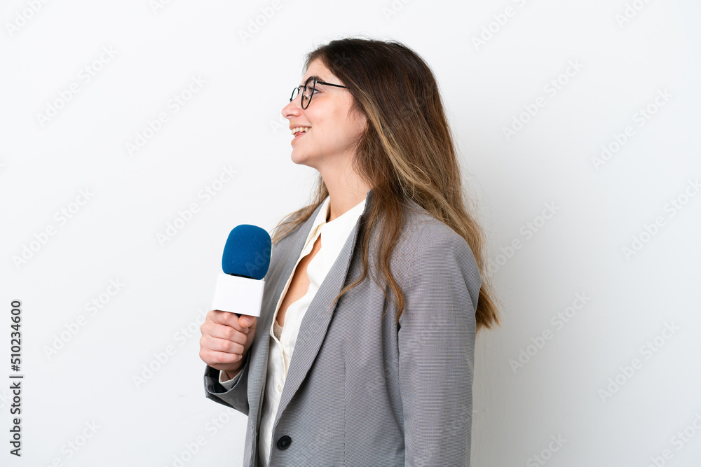 Young caucasian TV presenter woman isolated on white background laughing in lateral position Young caucasian TV presenter woman isolated on white background laughing in lateral position