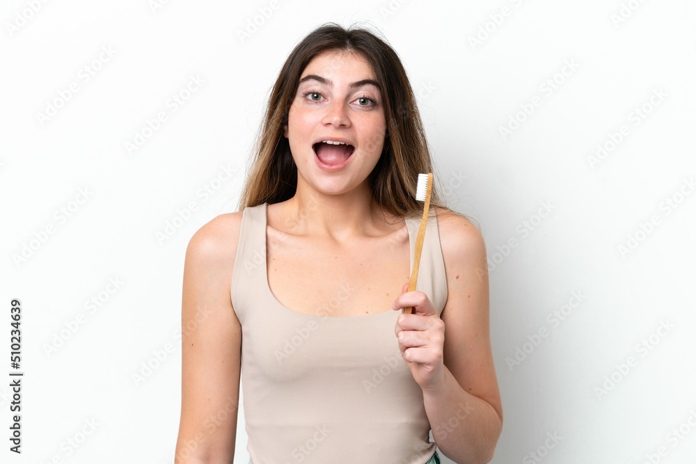 Young caucasian woman brushing teeth isolated on white background with surprise and shocked facial expression
