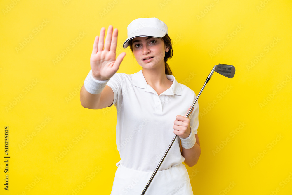 young caucasian woman playing golf isolated on yellow background making stop gesture young caucasian woman playing golf isolated on yellow background making stop gesture