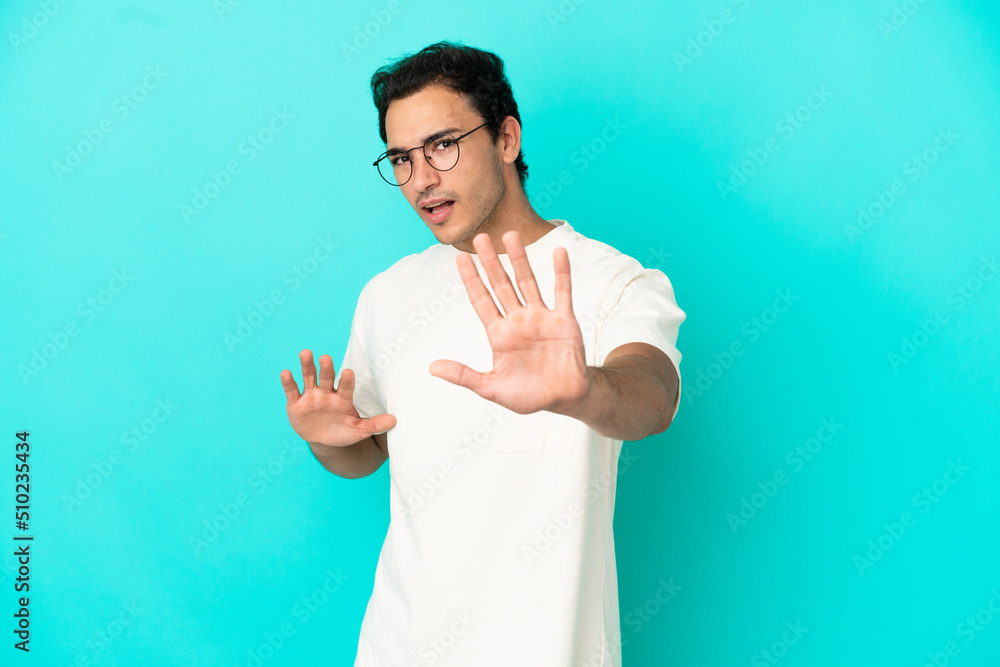 Caucasian handsome man over isolated blue background nervous stretching hands to the front Caucasian handsome man over isolated blue background nervous stretching hands to the front