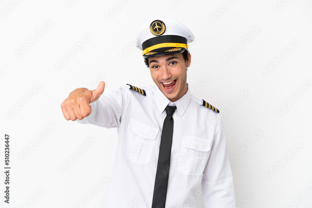Airplane pilot over isolated white background with thumbs up because something good has happened Airplane pilot over isolated white background with thumbs up because something good has happened