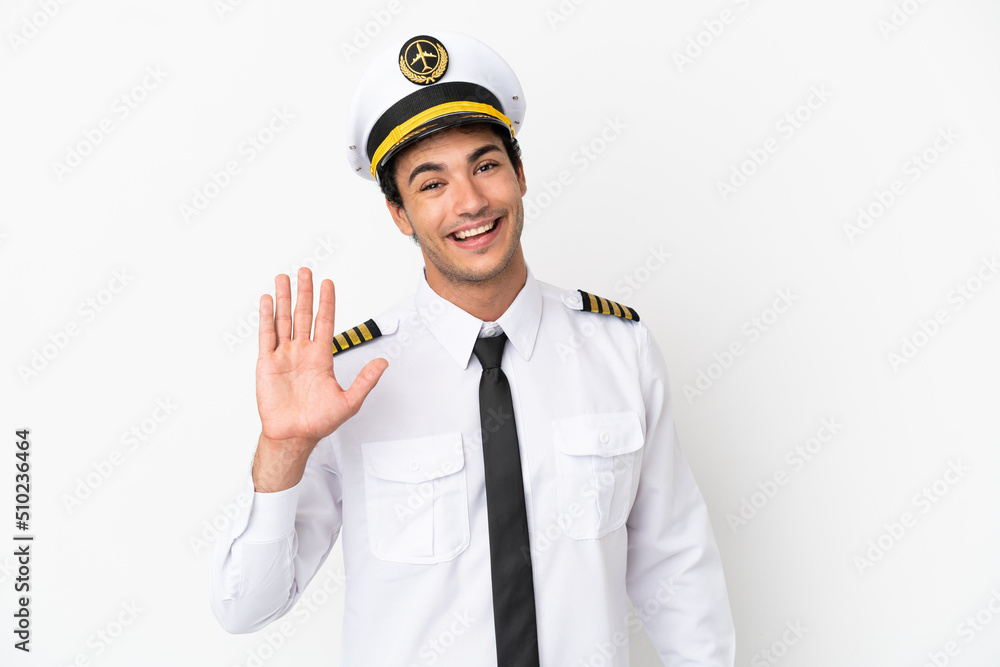 Airplane pilot over isolated white background saluting with hand with happy expression Airplane pilot over isolated white background saluting with hand with happy expression