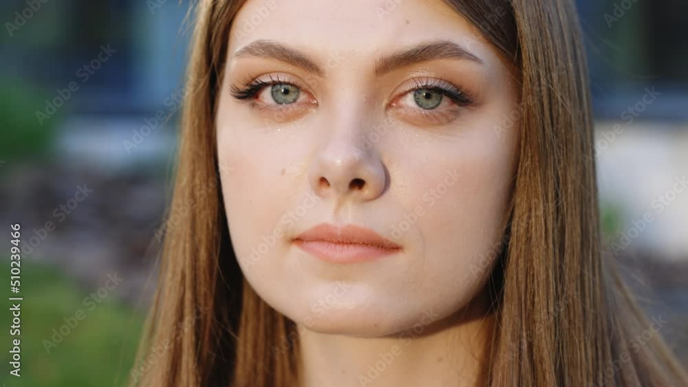 Face of beautiful ukrainian woman with natural make-up looking at camera. Portrait young caucasian pretty brunette girl outside at sunshine. Etnnicity. People. Beauty. Super slow motion 4k uhd. Face of beautiful ukrainian woman with natural make-up looking at camera. Portrait young caucasian pretty brunette girl outside at sunshine. Etnnicity. People. Beauty. Super slow motion 4k uhd.