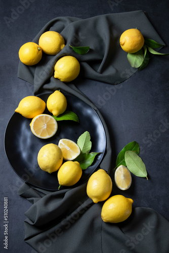 Raw fresh lemons on dark background. Harvest, agricultural concept, healthy organic ingredients