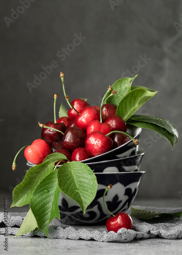 Fresh picked cherries in antique plates, dark food photography