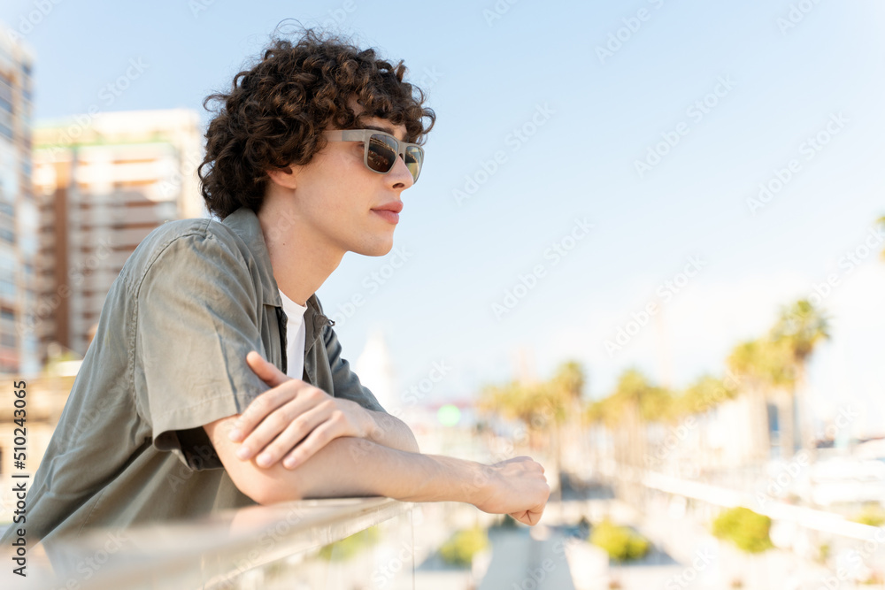 Young man wearing sunglasses posing on camera on the street Young man wearing sunglasses posing on camera on the street
