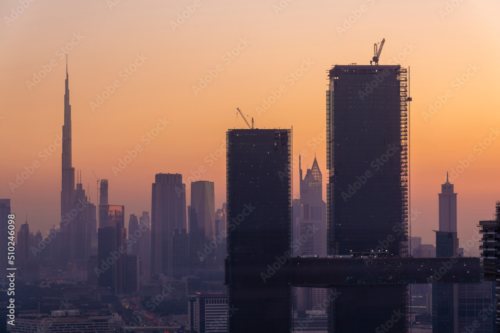 Dubai skyline by sunset with modern towers near Financial centre and trade center with Burj Khalifa in the background, Dubai, UAE