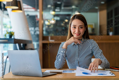 Portrait of beautiful asian woman working financial report with laptop computer at office.
