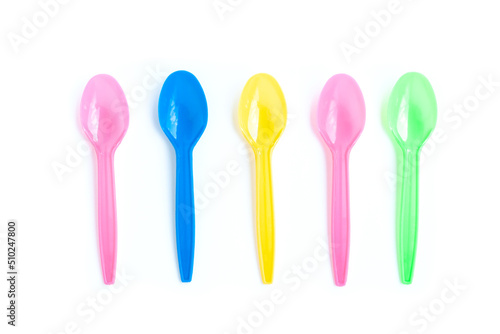 Multicolor plastic spoons on white background