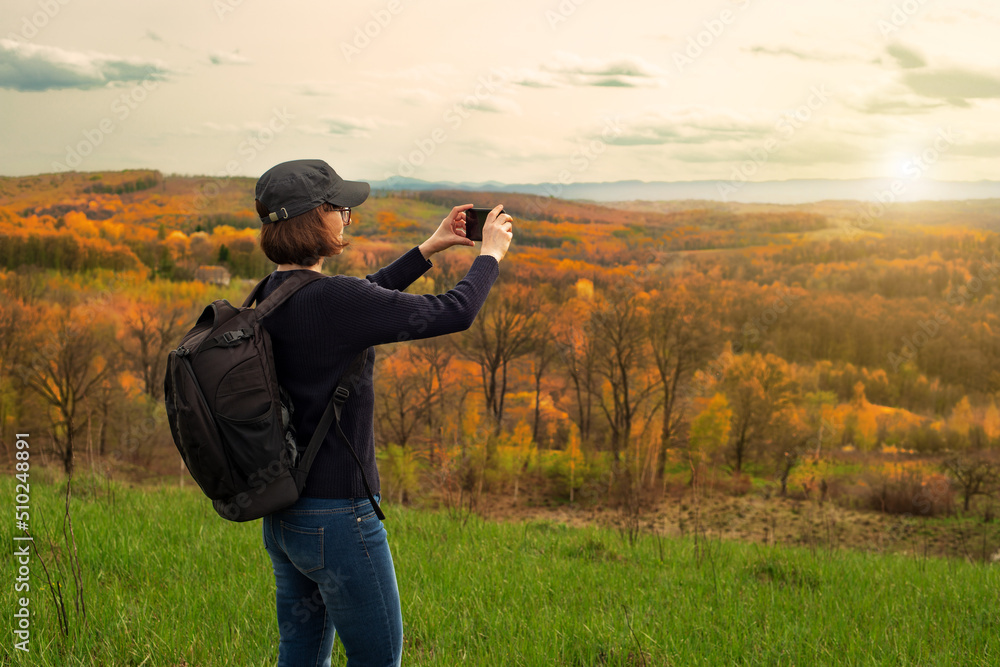 Middle aged female model makes selfie on smartphone at mountain background Middle aged female model makes selfie on smartphone at mountain background