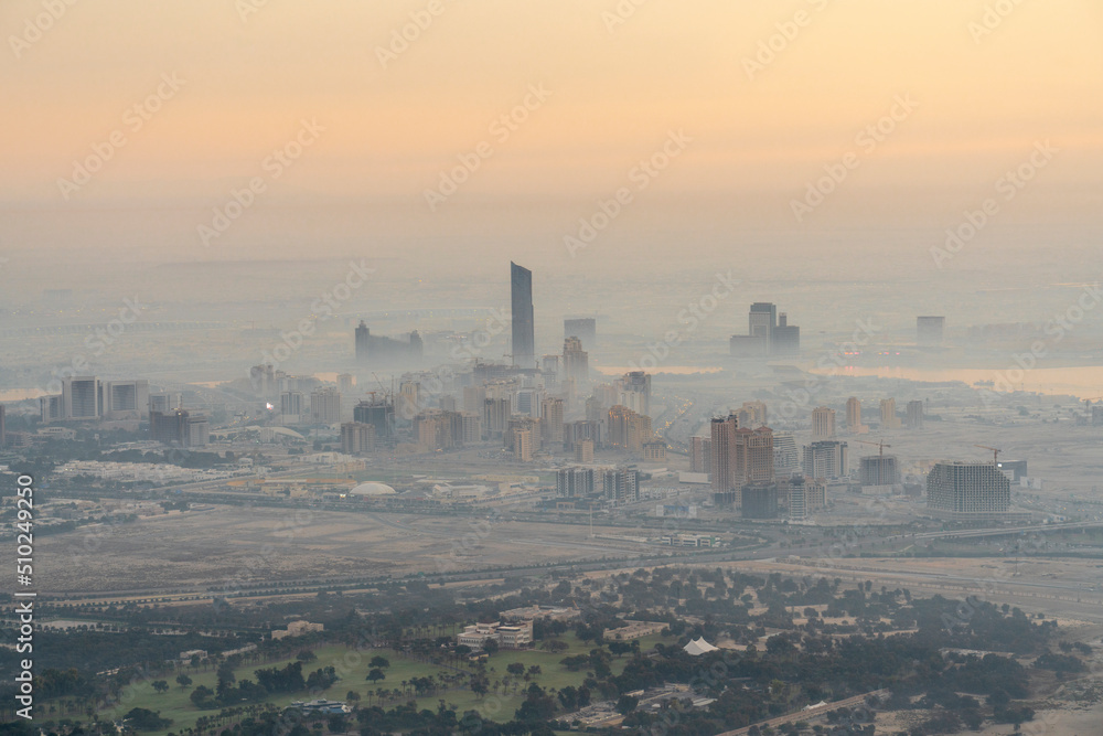 View of foggy skyline by sunrise of Dubai neighbourhood in the west of Dubai. 