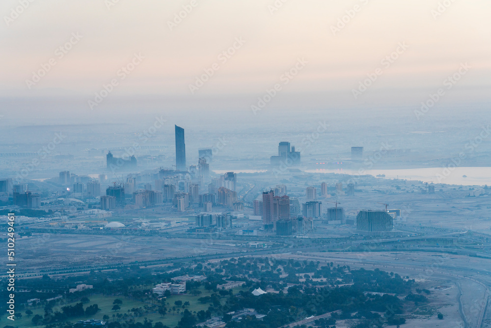 Fototapeta premium View of foggy skyline by sunrise of Dubai neighbourhood in the west of Dubai.