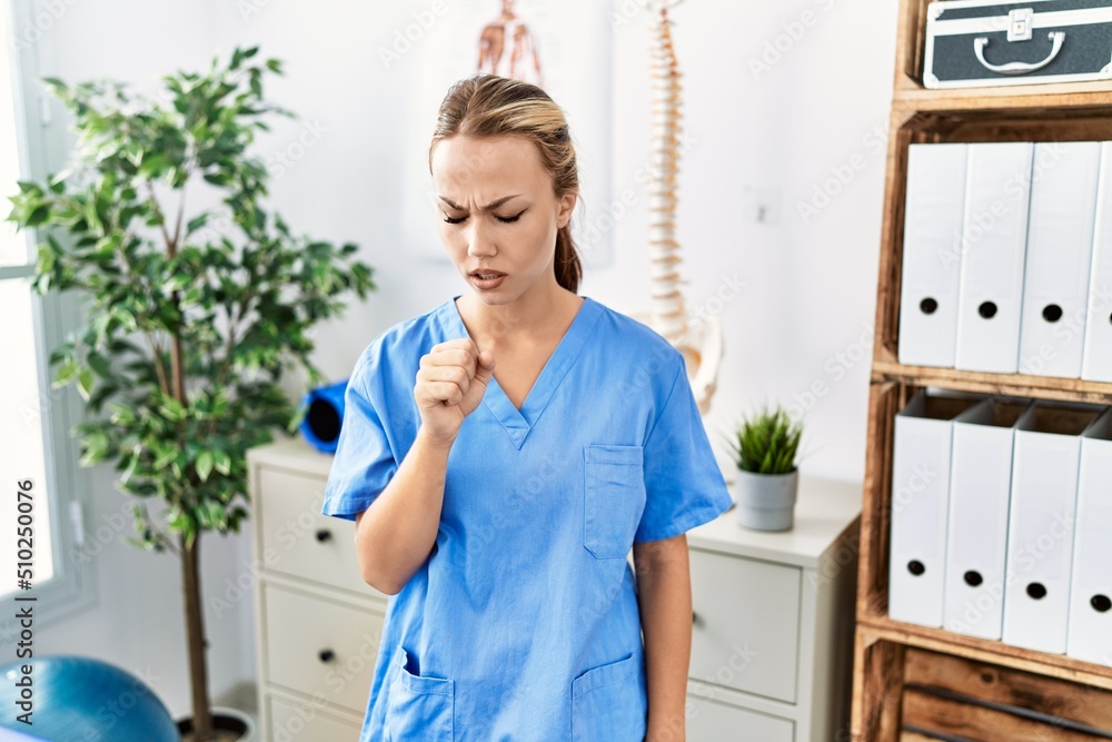 Young caucasian woman working at pain recovery clinic feeling unwell and coughing as symptom for cold or bronchitis. health care concept. Young caucasian woman working at pain recovery clinic feeling unwell and coughing as symptom for cold or bronchitis. health care concept.