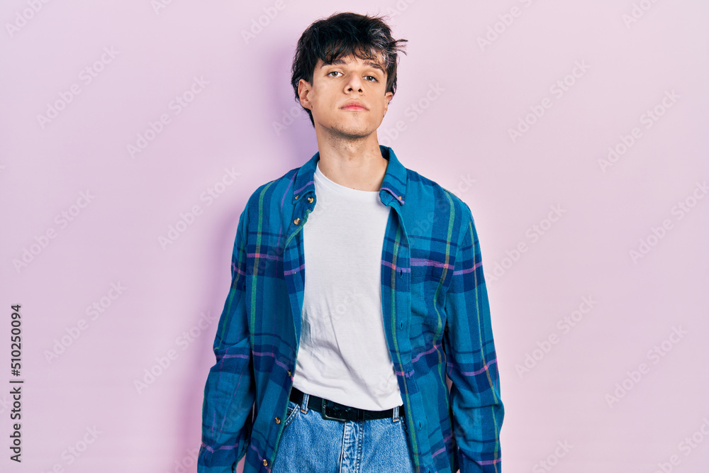 Handsome hipster young man wearing casual white t shirt and vintage shirt relaxed with serious expression on face. simple and natural looking at the camera. Handsome hipster young man wearing casual white t shirt and vintage shirt relaxed with serious expression on face. simple and natural looking at the camera.