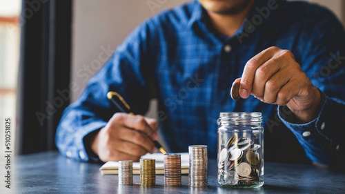 Businessman putting coins in glass bottles saving bank and account for his money all in finance accounting concept, for saving money wealth, Savings for Retirement Planning