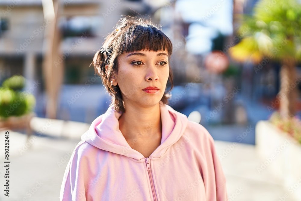 Young woman standing with relaxed expression at street