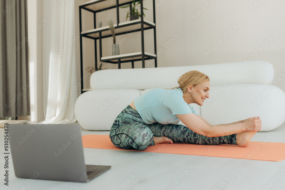 Fitness training online, senior woman at home with laptop Fitness training online, senior woman at home with laptop