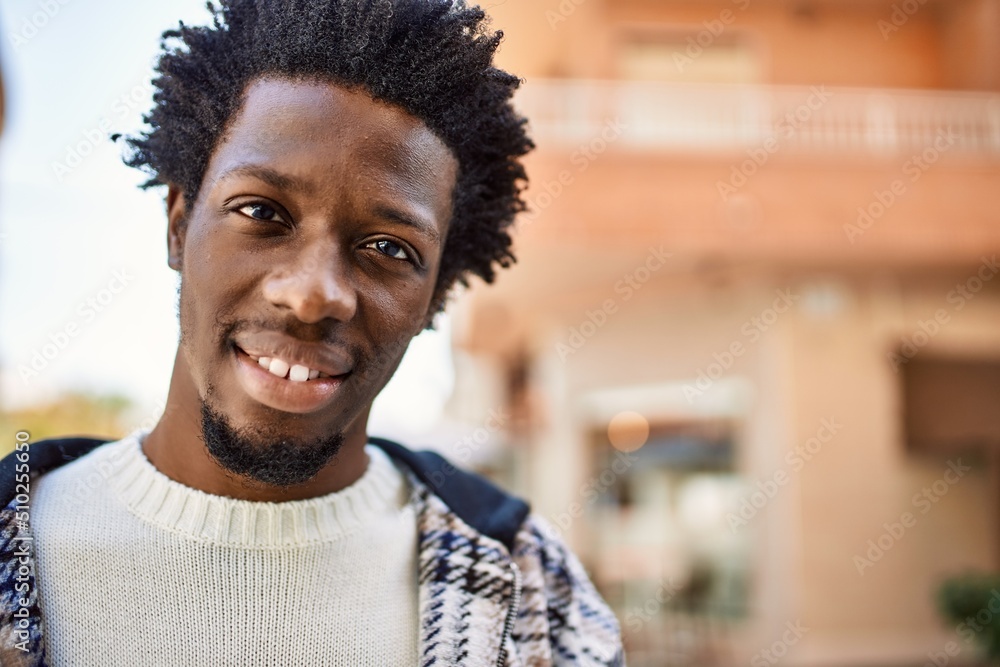 Handsome black man with afro hair and beard smiling happy outdoors Handsome black man with afro hair and beard smiling happy outdoors