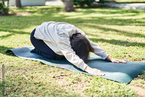 Middle age woman stretching back at park