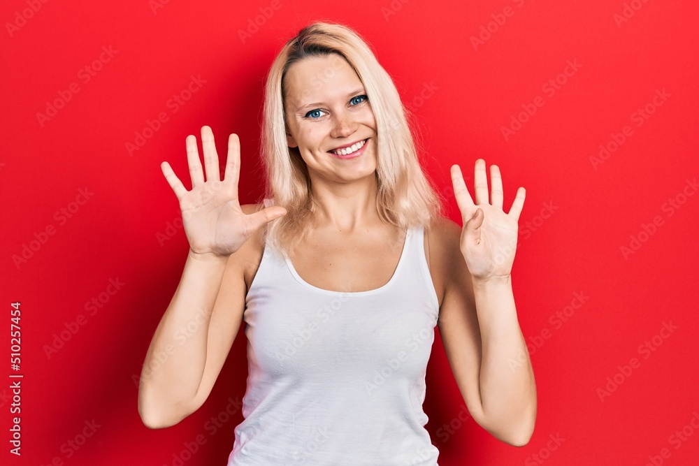 Beautiful caucasian blonde woman wearing casual white t shirt showing and pointing up with fingers number nine while smiling confident and happy. Beautiful caucasian blonde woman wearing casual white t shirt showing and pointing up with fingers number nine while smiling confident and happy.