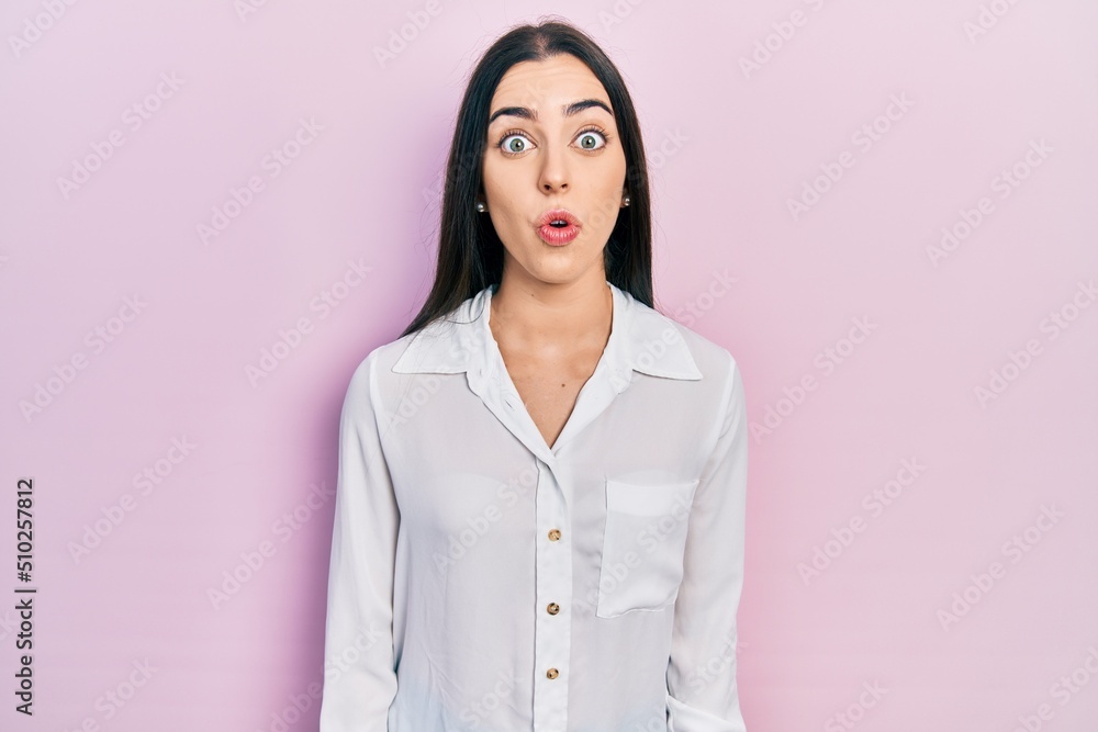 Beautiful woman with blue eyes wearing casual white shirt scared and amazed with open mouth for surprise, disbelief face Beautiful woman with blue eyes wearing casual white shirt scared and amazed with open mouth for surprise, disbelief face