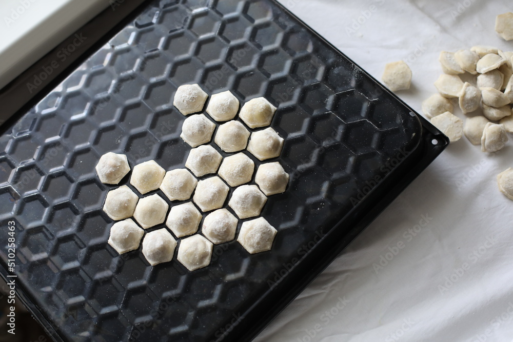 raw dumplings on a dish lined with a heart shape
raw dumplings on a dish lined with a heart shape