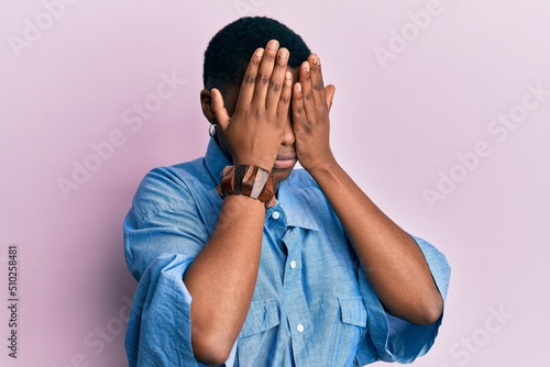 Young african american woman wearing casual clothes with sad expression covering face with hands while crying. depression concept.