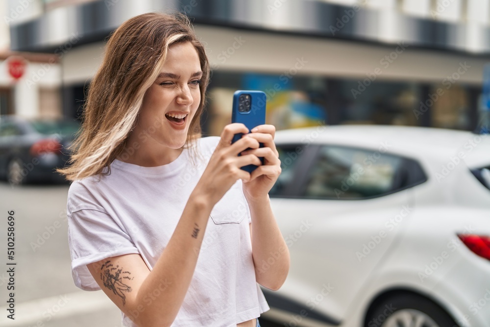 Young woman smiling confident making photo by smartphone at street