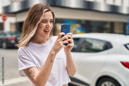 Young woman smiling confident making photo by smartphone at street
