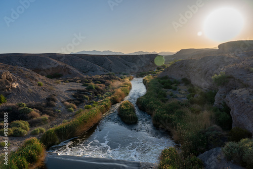 View of River Crossing the Nevada Desert With Sun Flare on the Right