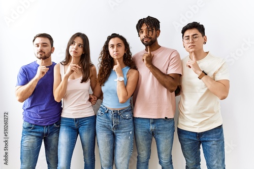 Fotografie Group of young people standing together over isolated background thinking concen
