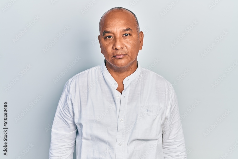 Middle age latin man wearing casual clothes relaxed with serious expression on face. simple and natural looking at the camera. Middle age latin man wearing casual clothes relaxed with serious expression on face. simple and natural looking at the camera.