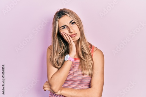 Beautiful hispanic woman wearing casual summer t shirt thinking looking tired and bored with depression problems with crossed arms.