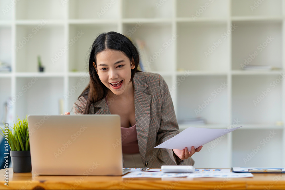 Happy Asian woman office worker feeling excitement raising fists celebrates career ladder promotion or reward, businesswoman sitting at desk receive online news, great results successful work concept Happy Asian woman office worker feeling excitement raising fists celebrates career ladder promotion or reward, businesswoman sitting at desk receive online news, great results successful work concept