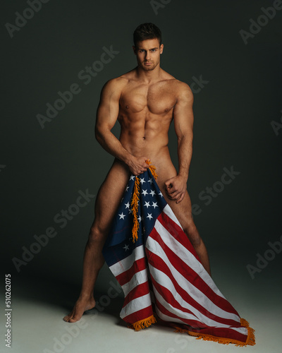 Sexy fitness male model with American flag covering his naked body photo