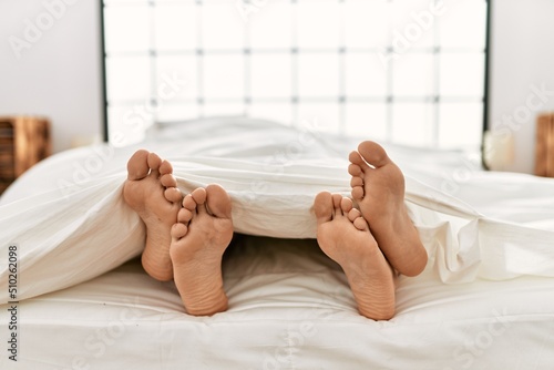 Two hispanic men couple lying on bed at bedroom photo