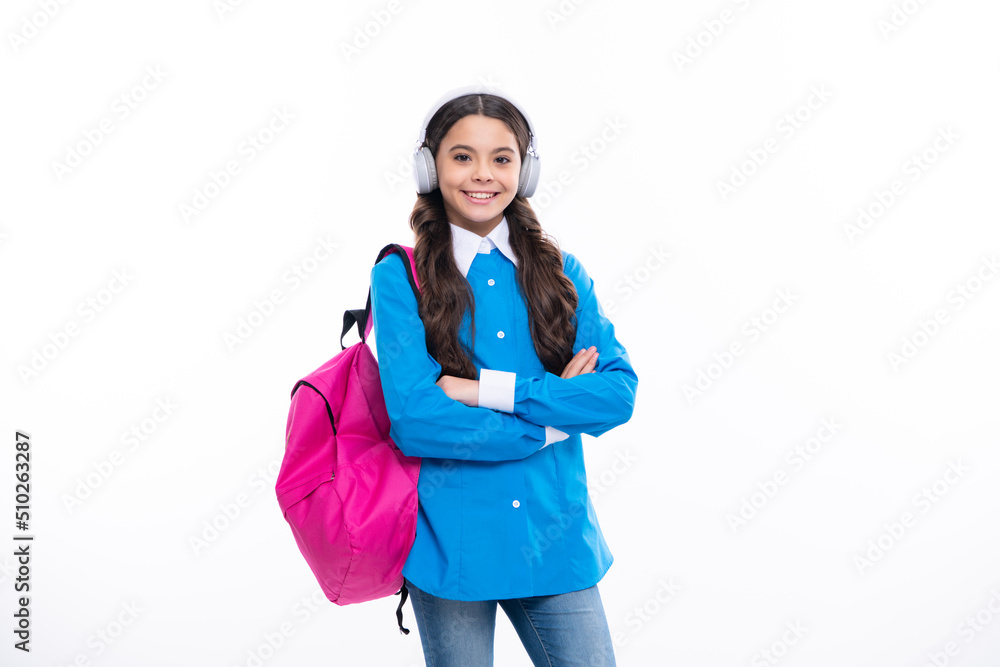School girl in headphones on isolated studio background. School and music concept. School girl in headphones on isolated studio background. School and music concept.