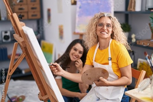 Two women artists smiling confident drawing at art studio