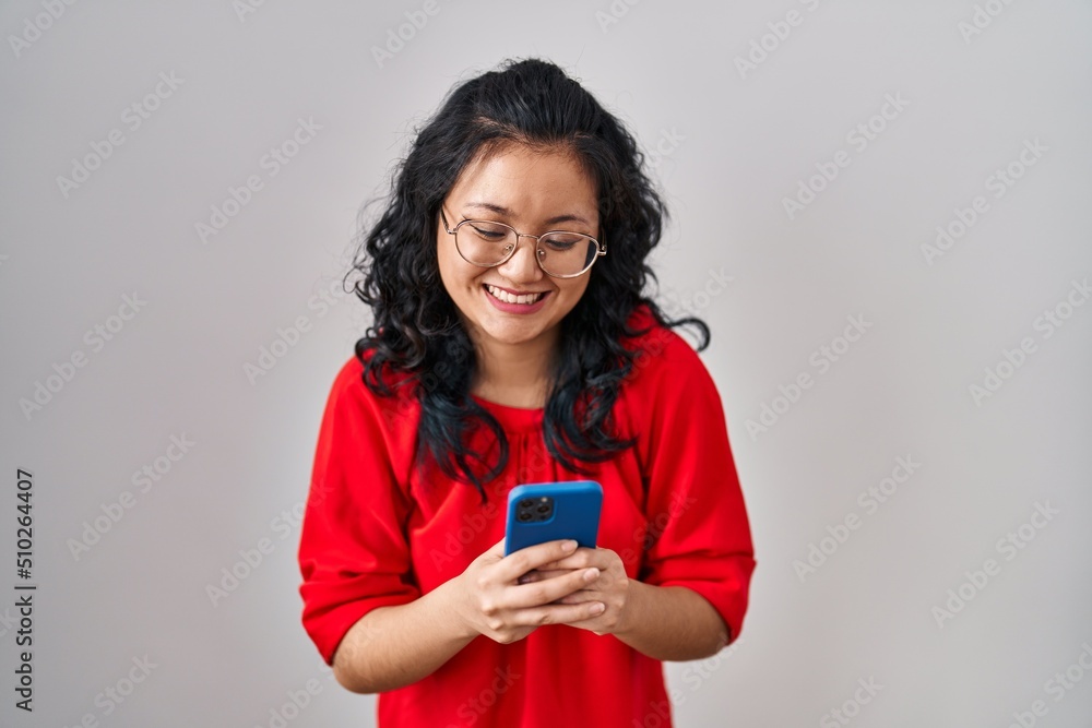 Young asian woman using smartphone typing message smiling and laughing hard out loud because funny crazy joke. Young asian woman using smartphone typing message smiling and laughing hard out loud because funny crazy joke.