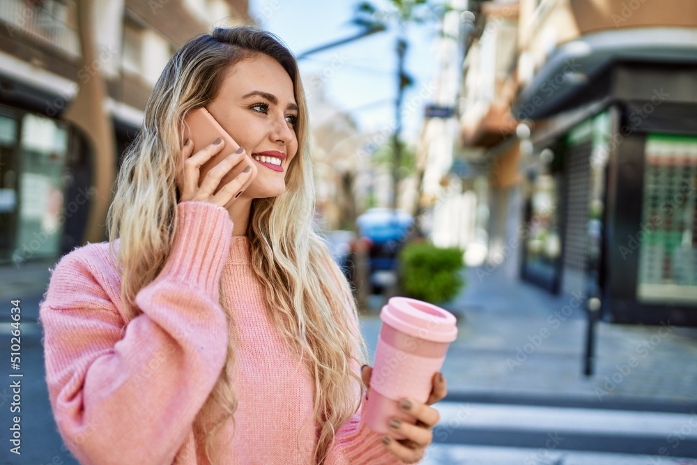 Young blonde woman speaking on the phone at the city