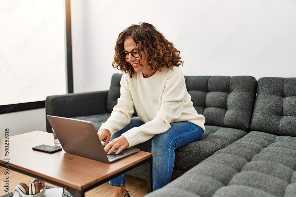 Middle age hispanic woman smiling confident using laptop at home Middle age hispanic woman smiling confident using laptop at home