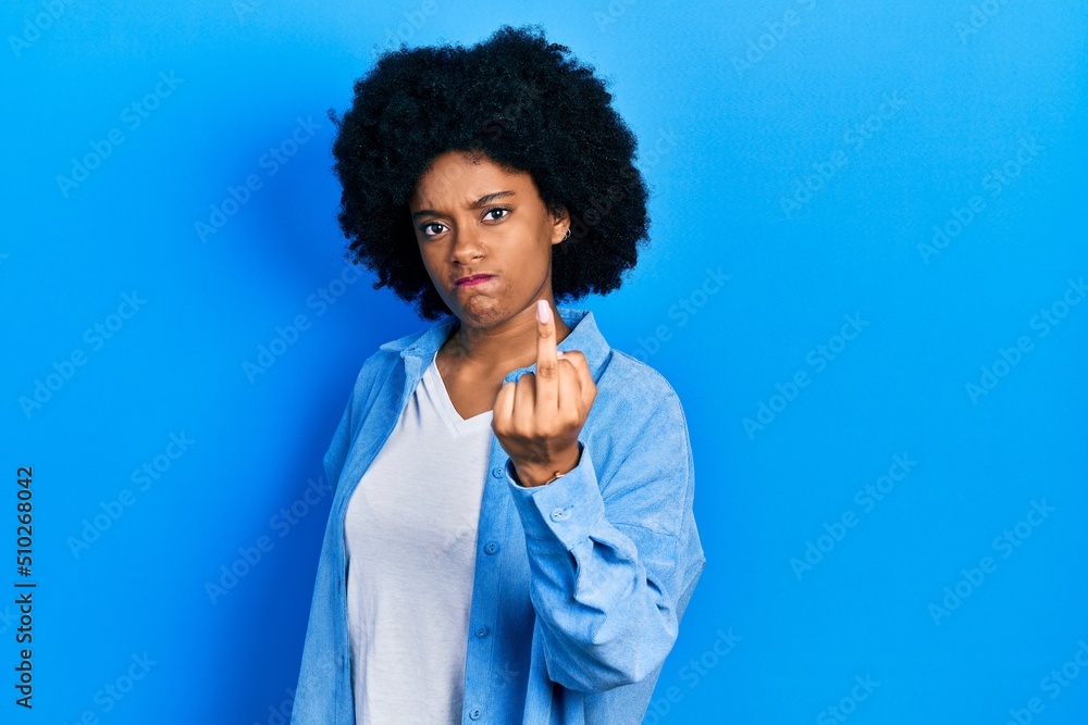 Young african american woman wearing casual clothes showing middle finger, impolite and rude fuck off expression Young african american woman wearing casual clothes showing middle finger, impolite and rude fuck off expression