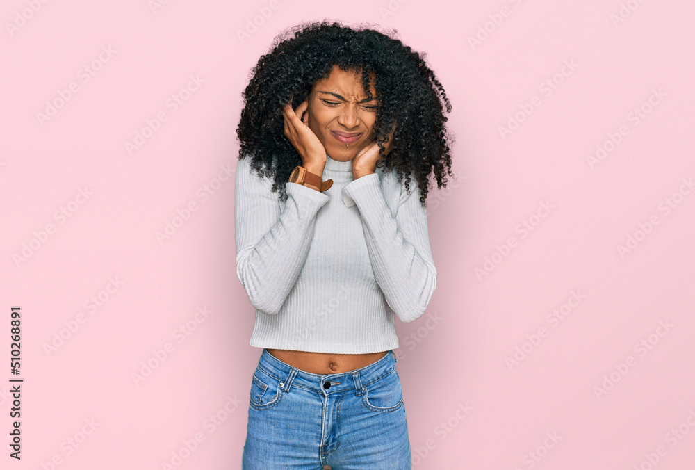Young african american girl wearing casual clothes covering ears with fingers with annoyed expression for the noise of loud music. deaf concept. Young african american girl wearing casual clothes covering ears with fingers with annoyed expression for the noise of loud music. deaf concept.