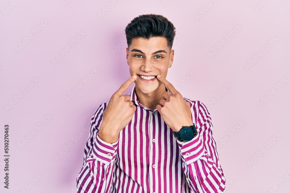 Young hispanic man wearing casual clothes smiling with open mouth, fingers pointing and forcing cheerful smile Young hispanic man wearing casual clothes smiling with open mouth, fingers pointing and forcing cheerful smile