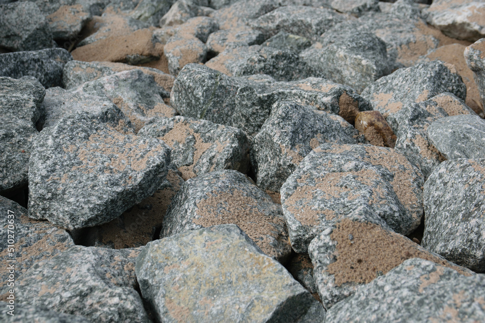 Fragments of granite on the river bank. Abstract texture background.